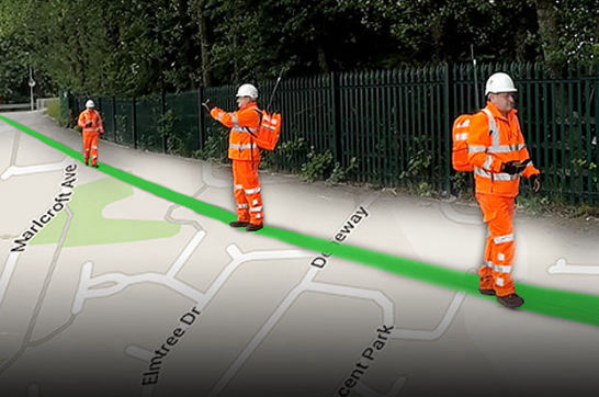 Men walking along a map filming rail access points