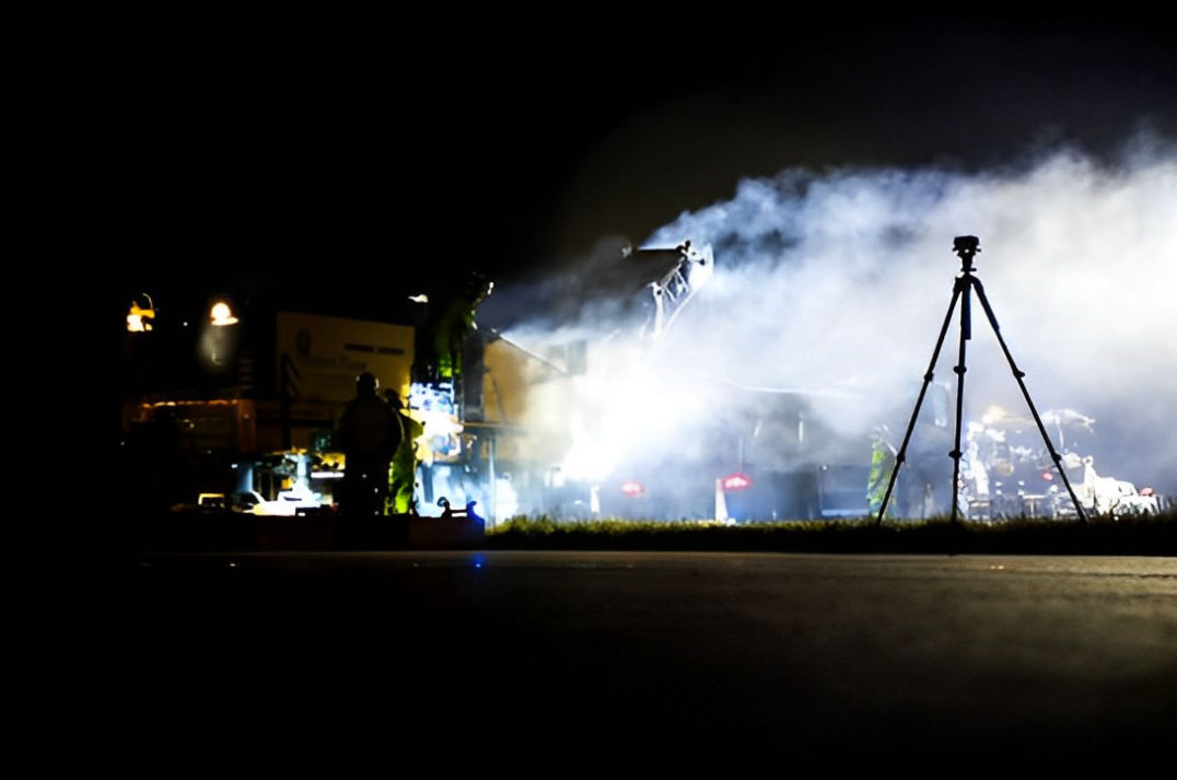 Camera on tripod filming a construction site at night