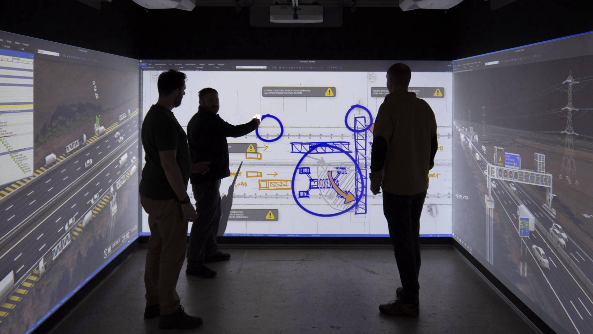 Three men previewing a project in a Cube